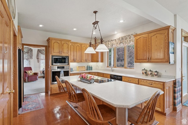 3136 W 2400th St S, Charleston, UT 84032 - kitchen with black appliances, light countertops, a breakfast bar area, light wood-style floors, and recessed lighting
