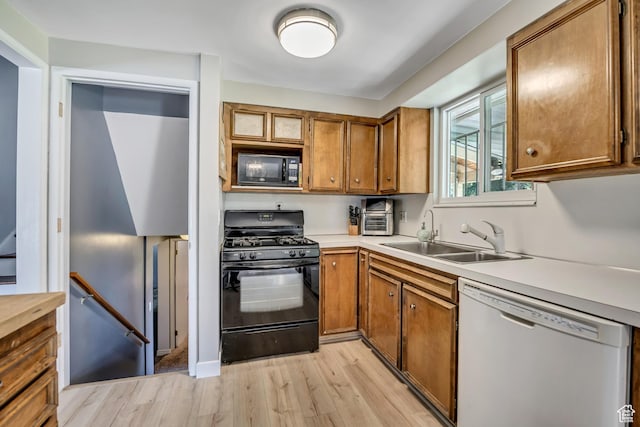 1261 E Sandra Cir, Murray, UT 84121 - kitchen with black appliances, light wood-style flooring, brown cabinets, and light countertops