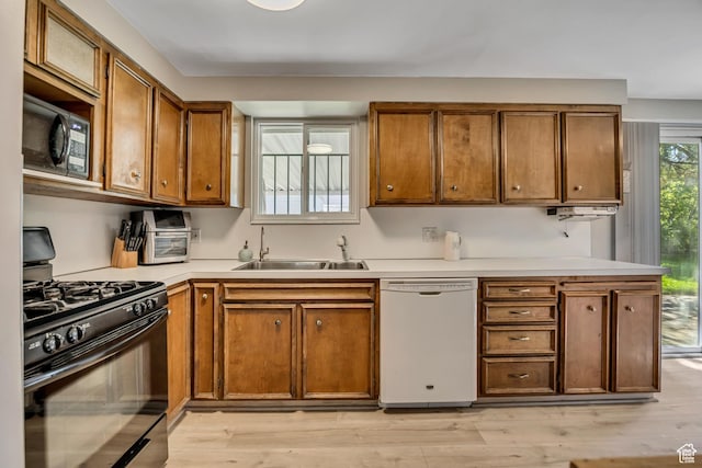 1261 E Sandra Cir, Murray, UT 84121 - kitchen with black appliances, brown cabinets, light wood finished floors, and light countertops