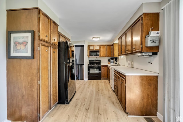 1261 E Sandra Cir, Murray, UT 84121 - kitchen featuring black appliances, brown cabinets, light wood-type flooring, light countertops, and open shelves