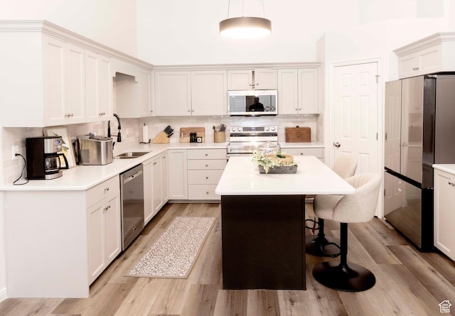 3482 W Plymouth Rock Cv, Lehi, UT 84043 - kitchen featuring stainless steel appliances, a breakfast bar area, light wood-style flooring, decorative backsplash, and a kitchen island
