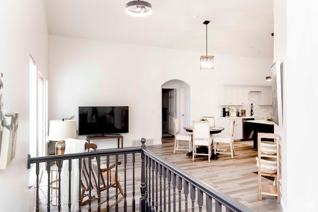 3482 W Plymouth Rock Cv, Lehi, UT 84043 - living room with arched walkways, light wood-style flooring, and a towering ceiling