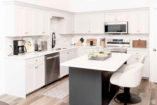 3482 W Plymouth Rock Cv, Lehi, UT 84043 - kitchen with stainless steel appliances, a kitchen bar, light wood finished floors, and decorative backsplash