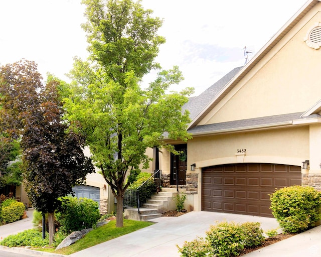 3482 W Plymouth Rock Cv, Lehi, UT 84043 - view of front of house with stucco siding, stone siding, driveway, and an attached garage