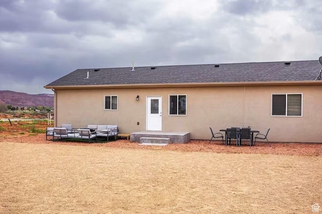 1468 S Sage Ct S Unit 13, Kanab, UT 84741 - back of house featuring stucco siding, a patio area, an outdoor living space, a shingled roof, and a mountain view