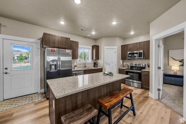 1468 S Sage Ct S Unit 13, Kanab, UT 84741 - kitchen featuring appliances with stainless steel finishes, dark brown cabinets, a center island, a kitchen bar, and recessed lighting