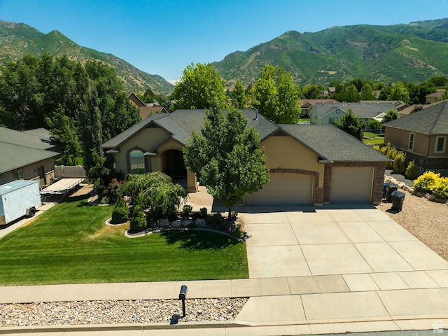 7496 S 1740 E, South Weber, UT 84405 - view of front facade featuring a garage, a mountain view, concrete driveway, a front yard, and brick siding