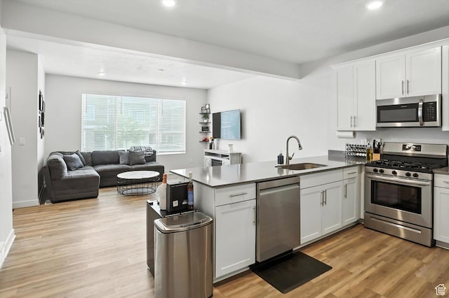 3724 W Soft Whisper Way, Herriman, UT 84096 - kitchen featuring appliances with stainless steel finishes, a peninsula, open floor plan, white cabinetry, and recessed lighting