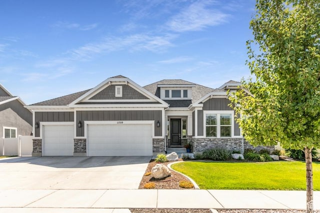 11709 S 2610 W, Riverton, UT 84065 - craftsman-style home with board and batten siding, an attached garage, a front lawn, stone siding, and driveway