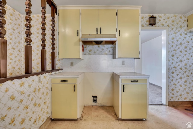 5764 S Hansen Cir E, Murray, UT 84107 - kitchen featuring under cabinet range hood, light countertops, cream cabinetry, and wallpapered walls