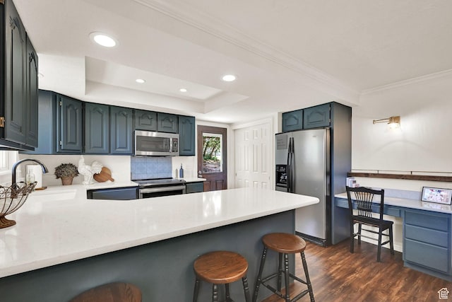 2779 E 3575 N, Layton, UT 84040 - kitchen featuring appliances with stainless steel finishes, a peninsula, a kitchen breakfast bar, dark wood-style flooring, and light countertops
