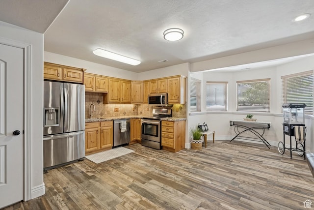 294 W Willow Ct Unit 12, Francis, UT 84036 - kitchen featuring stainless steel appliances, wood finished floors, backsplash, and light stone counters