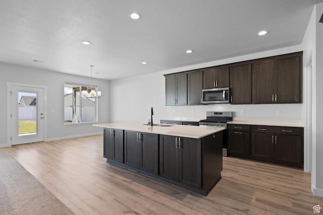 3105 W 3150 N, Plain City, UT 84404 - kitchen with appliances with stainless steel finishes, a chandelier, light wood-style flooring, light countertops, and a center island with sink