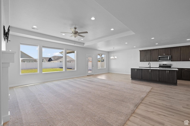 3105 W 3150 N, Plain City, UT 84404 - unfurnished living room with a ceiling fan, recessed lighting, healthy amount of natural light, light wood-style flooring, and a tray ceiling