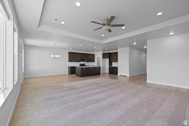 3105 W 3150 N, Plain City, UT 84404 - unfurnished living room featuring recessed lighting, ceiling fan, a tray ceiling, light colored carpet, and a chandelier
