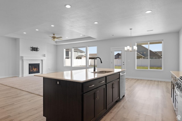 3105 W 3150 N, Plain City, UT 84404 - kitchen featuring a warm lit fireplace, light wood-style flooring, light countertops, dishwasher, and recessed lighting