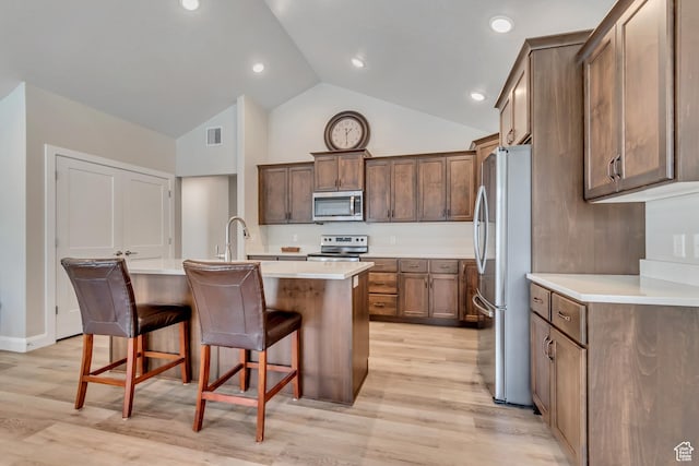 453 S Short Horse Ln Unit C, Saratoga Springs, UT 84045 - kitchen with appliances with stainless steel finishes, a kitchen island with sink, light countertops, a kitchen bar, and high vaulted ceiling