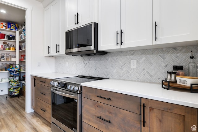 507 N 3650 W, Hurricane, UT 84737 - kitchen with stainless steel appliances, white cabinets, light wood-type flooring, light countertops, and backsplash