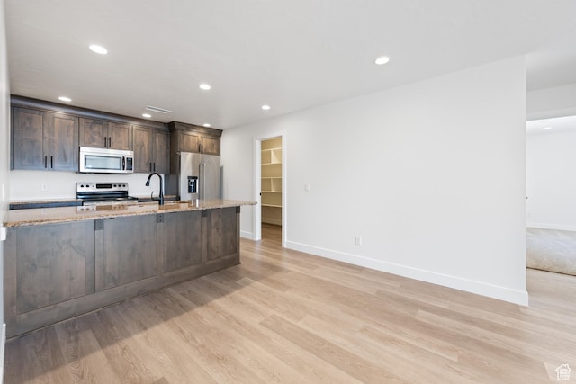 507 N 3650 W, Hurricane, UT 84737 - kitchen featuring appliances with stainless steel finishes, light wood finished floors, dark brown cabinets, light stone countertops, and recessed lighting