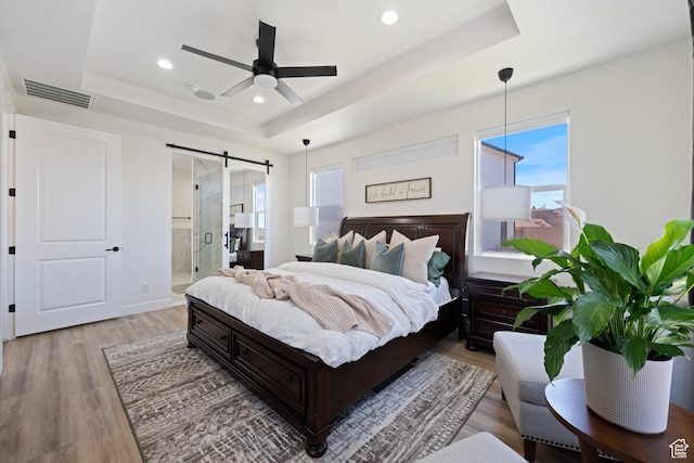 507 N 3650 W, Hurricane, UT 84737 - bedroom with a tray ceiling, a barn door, light wood finished floors, recessed lighting, and connected bathroom