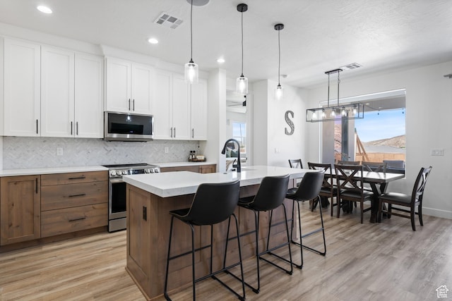 507 N 3650 W, Hurricane, UT 84737 - kitchen featuring stainless steel appliances, light countertops, tasteful backsplash, an island with sink, and white cabinets
