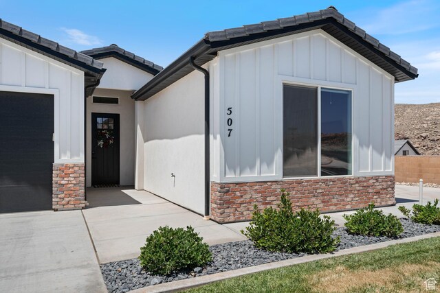 507 N 3650 W, Hurricane, UT 84737 - view of exterior entry featuring board and batten siding, stone siding, and an attached garage