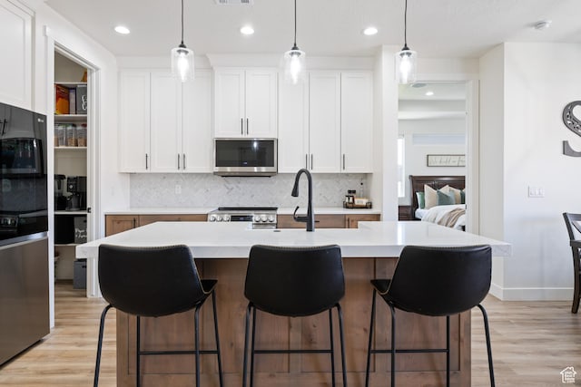 507 N 3650 W, Hurricane, UT 84737 - kitchen with stainless steel appliances, decorative backsplash, light wood-type flooring, white cabinets, and recessed lighting
