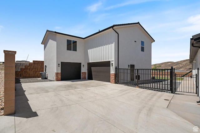 507 N 3650 W, Hurricane, UT 84737 - view of side of home featuring a garage, driveway, board and batten siding, a mountain view, and a gate