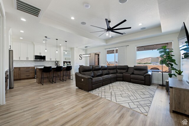507 N 3650 W, Hurricane, UT 84737 - living area featuring a tray ceiling, light wood-type flooring, ceiling fan, and recessed lighting