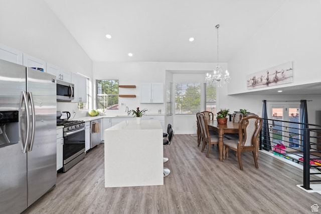 9375 S Laurel Ridge Cir, West Jordan, UT 84088 - kitchen with stainless steel appliances, open shelves, light countertops, light wood-style floors, and high vaulted ceiling