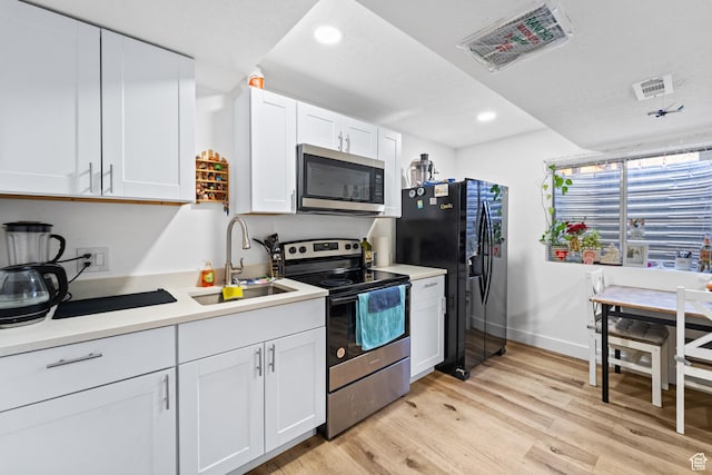 9375 S Laurel Ridge Cir, West Jordan, UT 84088 - kitchen with stainless steel appliances, recessed lighting, light wood-style flooring, white cabinetry, and light countertops