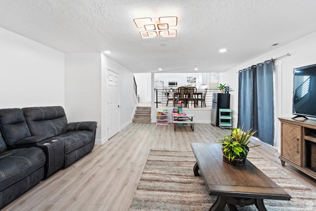 9375 S Laurel Ridge Cir, West Jordan, UT 84088 - living area with light wood finished floors, a textured ceiling, stairway, and recessed lighting