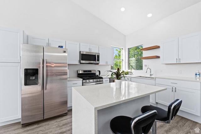 9375 S Laurel Ridge Cir, West Jordan, UT 84088 - kitchen featuring stainless steel appliances, light wood-style floors, high vaulted ceiling, open shelves, and a kitchen island