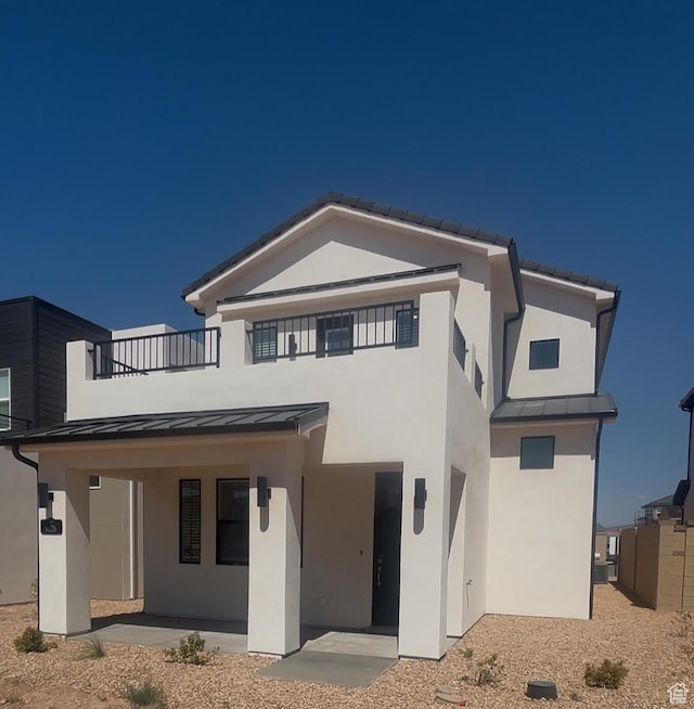 6126 S Kelly Ln, St George, UT 84790 - rear view of house featuring a standing seam roof, stucco siding, a balcony, and a metal roof