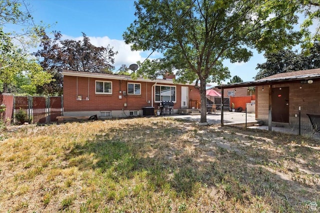 3524 W Meadowbrook Dr, West Valley City, UT 84119 - back of property featuring a patio area, a chimney, and brick siding