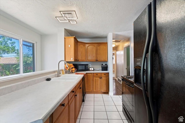 3524 W Meadowbrook Dr, West Valley City, UT 84119 - kitchen featuring black appliances, light tile patterned floors, light countertops, brown cabinets, and a textured ceiling