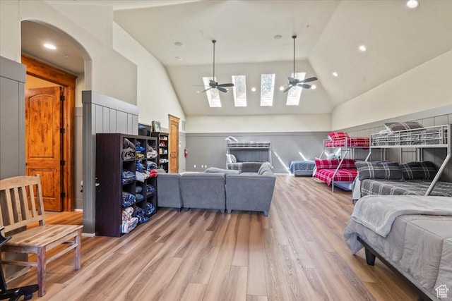 3149 E 9800 S, Sandy, UT 84092 - living area featuring a ceiling fan, light wood finished floors, a skylight, arched walkways, and high vaulted ceiling