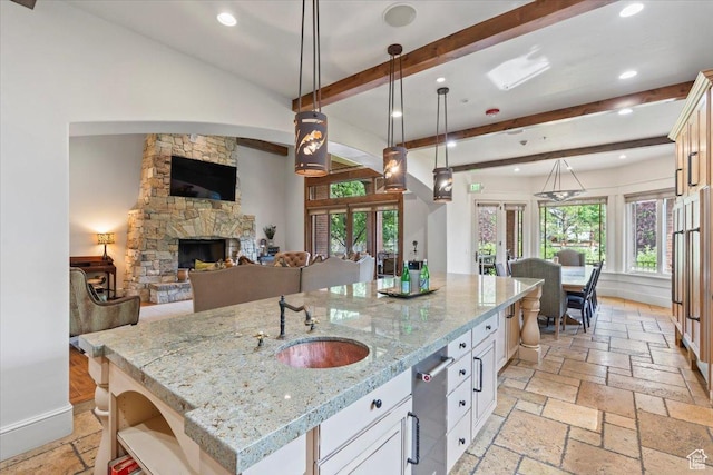 3149 E 9800 S, Sandy, UT 84092 - kitchen with open floor plan, beam ceiling, an island with sink, recessed lighting, and a fireplace