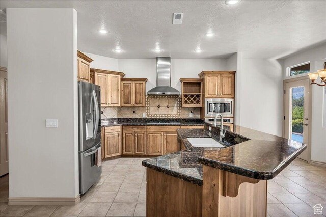 1319 W Red Butte Dr W, Washington, UT 84780 - kitchen featuring wall chimney range hood, appliances with stainless steel finishes, backsplash, open shelves, and an island with sink