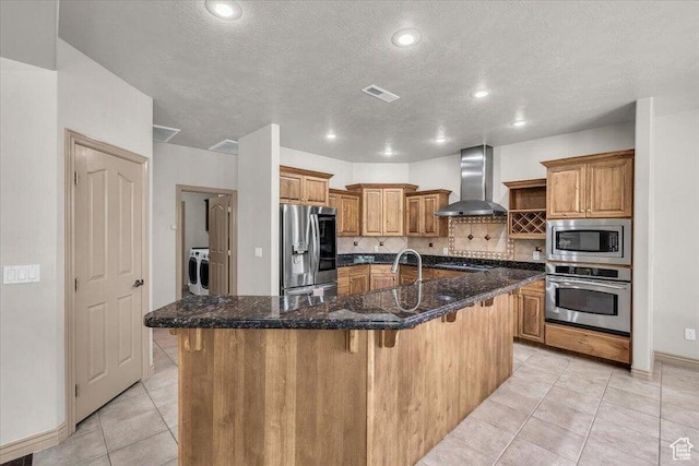 1319 W Red Butte Dr W, Washington, UT 84780 - kitchen with wall chimney exhaust hood, stainless steel appliances, light tile patterned floors, a textured ceiling, and a kitchen bar
