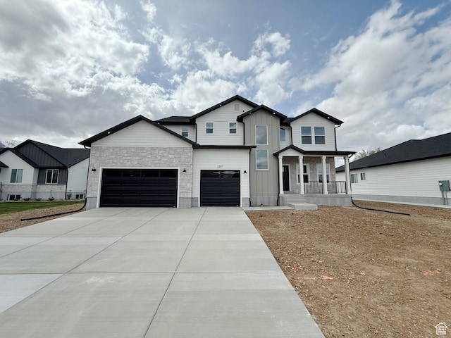 2237 E Parkside Cir S, South Ogden, UT 84403 - view of front of property featuring a porch, concrete driveway, board and batten siding, stone siding, and a garage