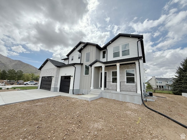 2237 E Parkside Cir S, South Ogden, UT 84403 - view of front facade with covered porch, concrete driveway, a mountain view, board and batten siding, and an attached garage