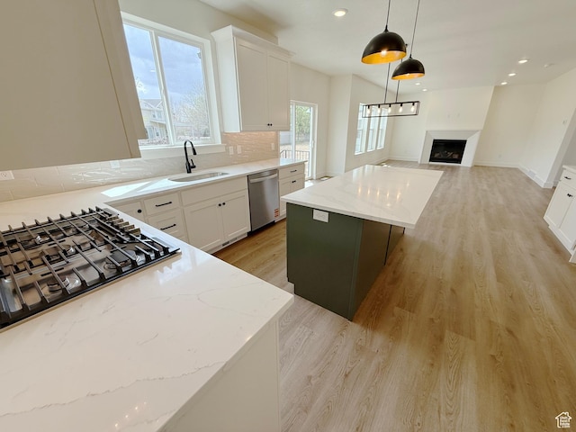 2237 E Parkside Cir S, South Ogden, UT 84403 - kitchen featuring appliances with stainless steel finishes, a center island, open floor plan, a fireplace, and light wood-type flooring