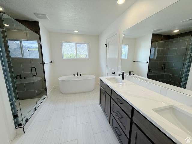2237 E Parkside Cir S, South Ogden, UT 84403 - bathroom with a shower stall, double vanity, a freestanding tub, recessed lighting, and a textured ceiling