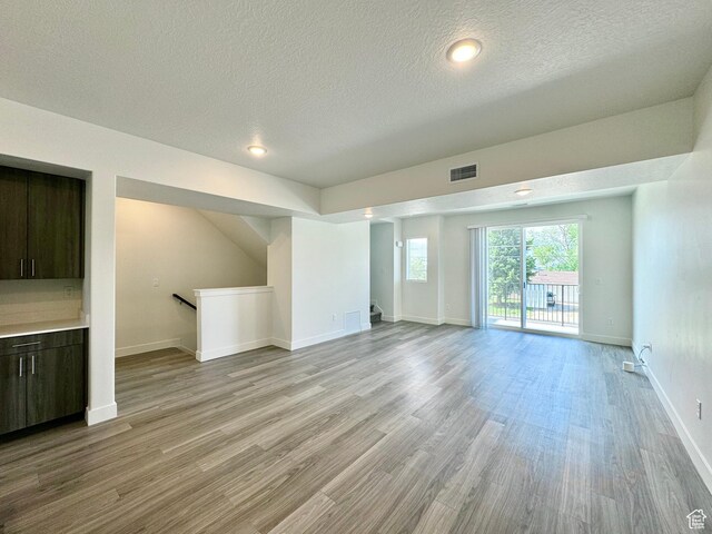2345 W Miles Unit D15, West Haven, UT 84401 - unfurnished living room with a textured ceiling, light wood-style flooring, and recessed lighting