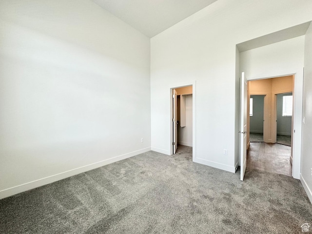 2345 W Miles Unit D15, West Haven, UT 84401 - unfurnished bedroom with carpet floors, a walk in closet, and a towering ceiling