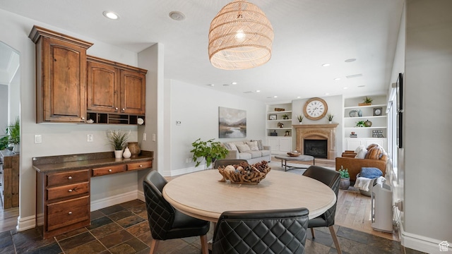 11597 N Sunset Hills Dr, Highland, UT 84003 - dining room with built in features, a fireplace with raised hearth, stone tile flooring, recessed lighting, and an office area