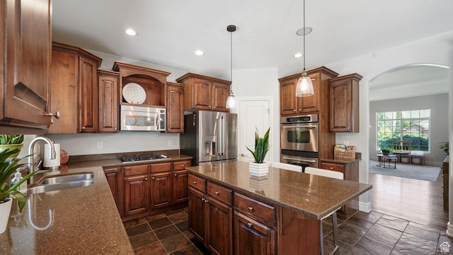 11597 N Sunset Hills Dr, Highland, UT 84003 - kitchen featuring appliances with stainless steel finishes, arched walkways, recessed lighting, a kitchen breakfast bar, and a kitchen island