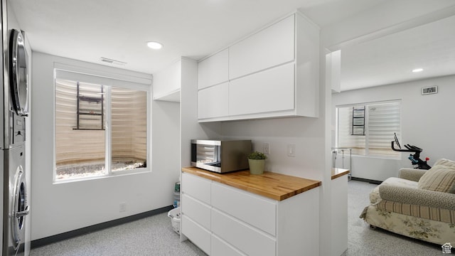 11597 N Sunset Hills Dr, Highland, UT 84003 - kitchen featuring stacked washing machine and dryer, butcher block countertops, white cabinetry, recessed lighting, and modern cabinets