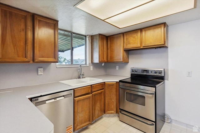 2989 W 700 S, Syracuse, UT 84075 - kitchen with appliances with stainless steel finishes, light countertops, brown cabinets, and a textured ceiling